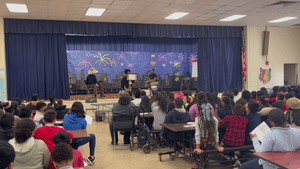 auditorium with adults and kids watching a play onstage