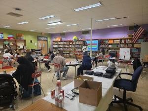 Mia speaking in front of group in library